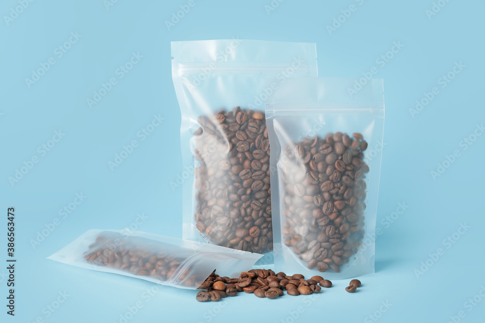 Blank coffee bags on color background