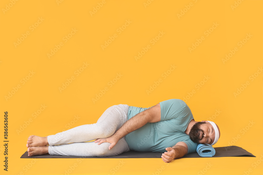 Lazy overweight man sleeping on color background instead of practicing yoga