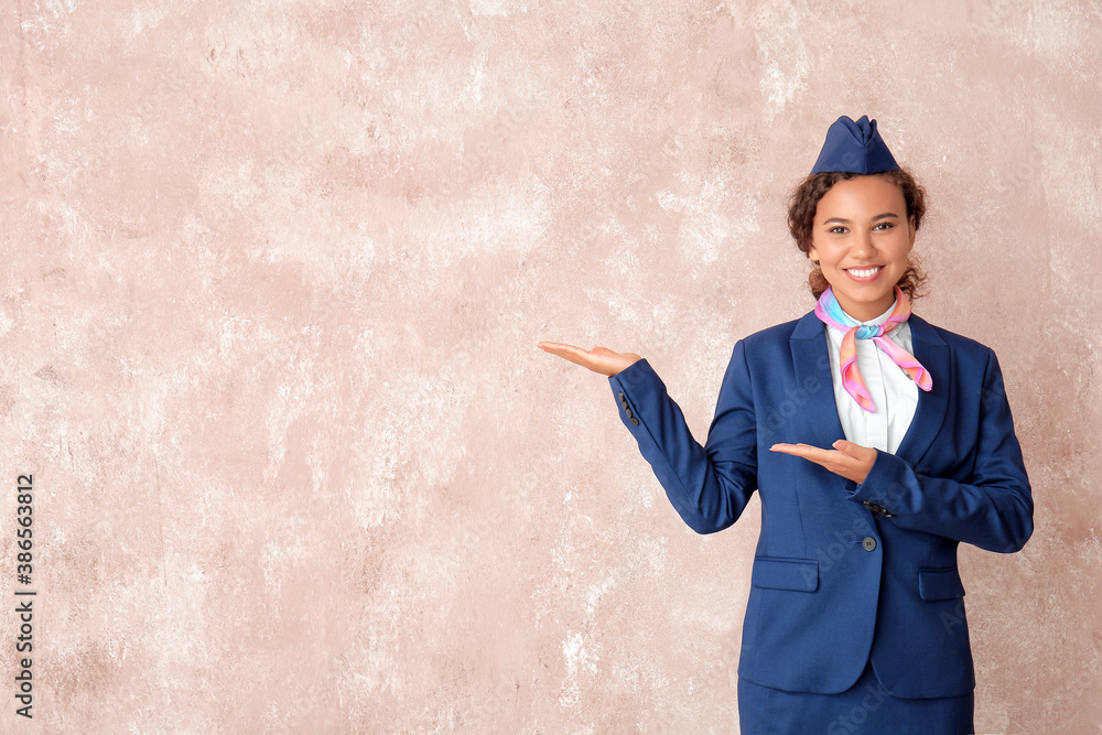 Beautiful African-American stewardess on color background