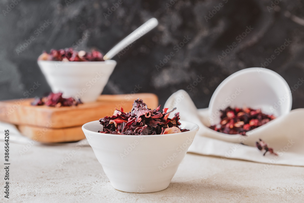 Bowl with dry hibiscus tea on table