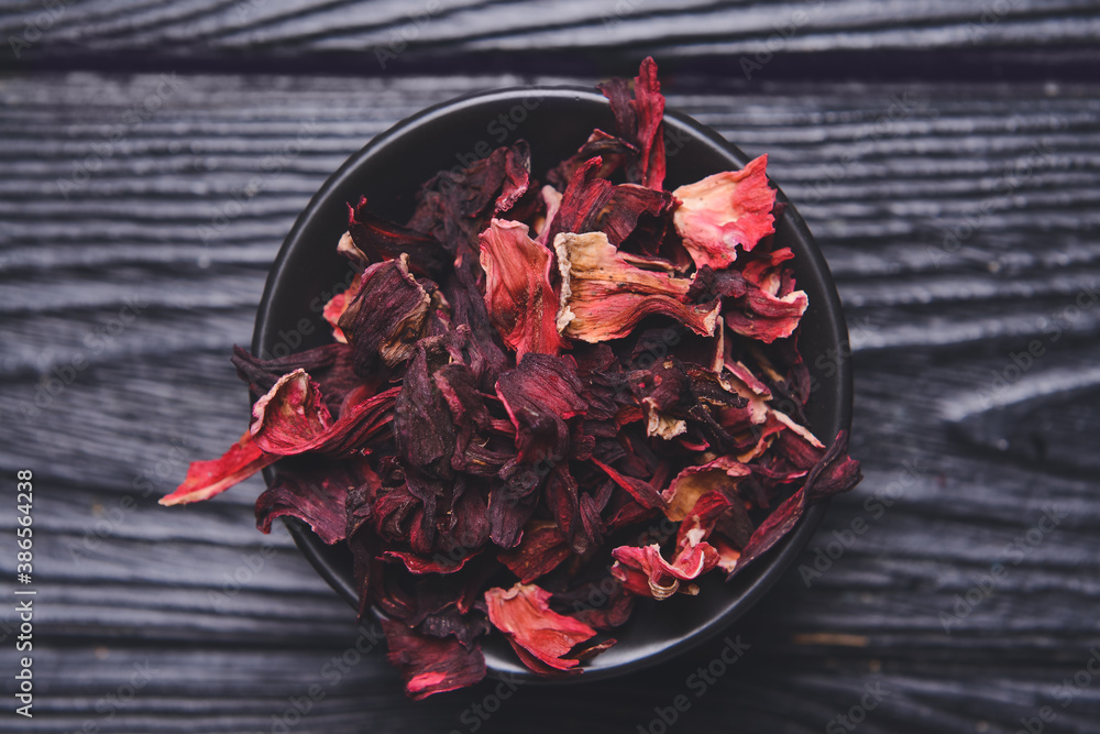 Bowl with dry hibiscus tea on table