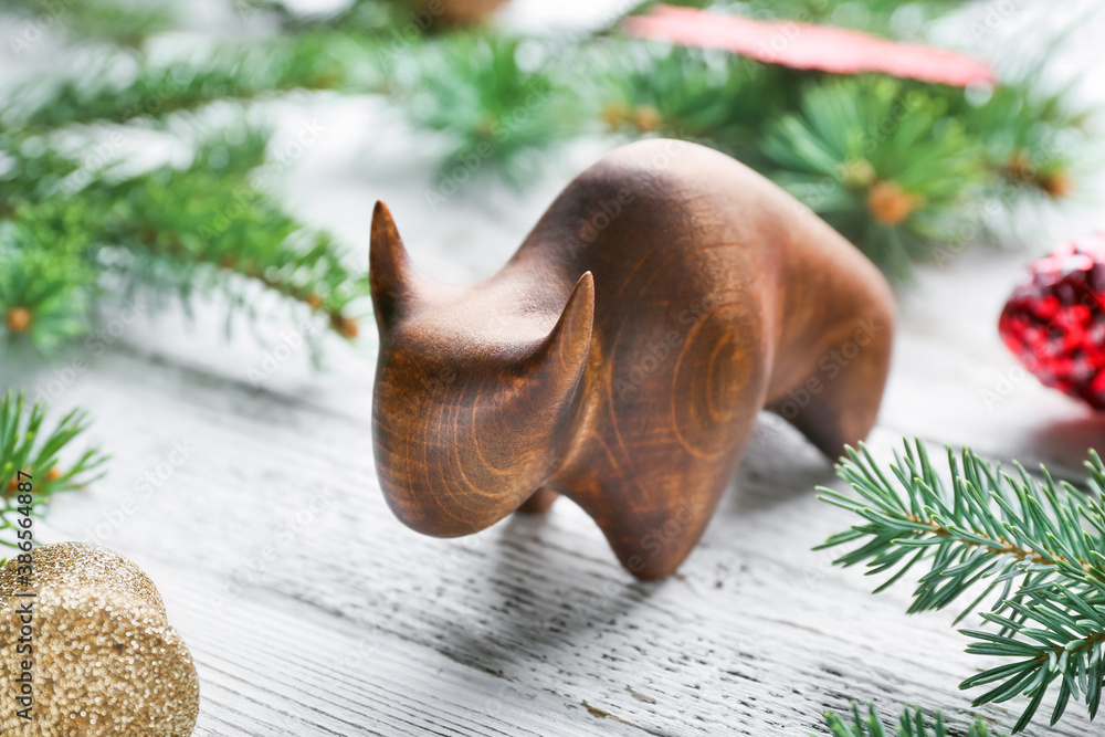 Figurine of bull and New Year decor on wooden background