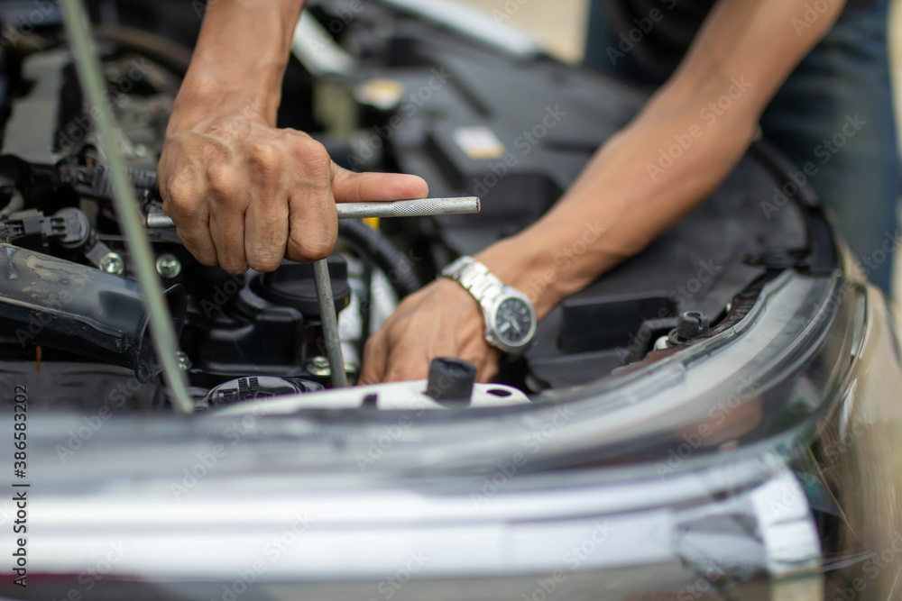 Automobile mechanic repairman hands repairing a car engine automotive workshop with a wrench, car se