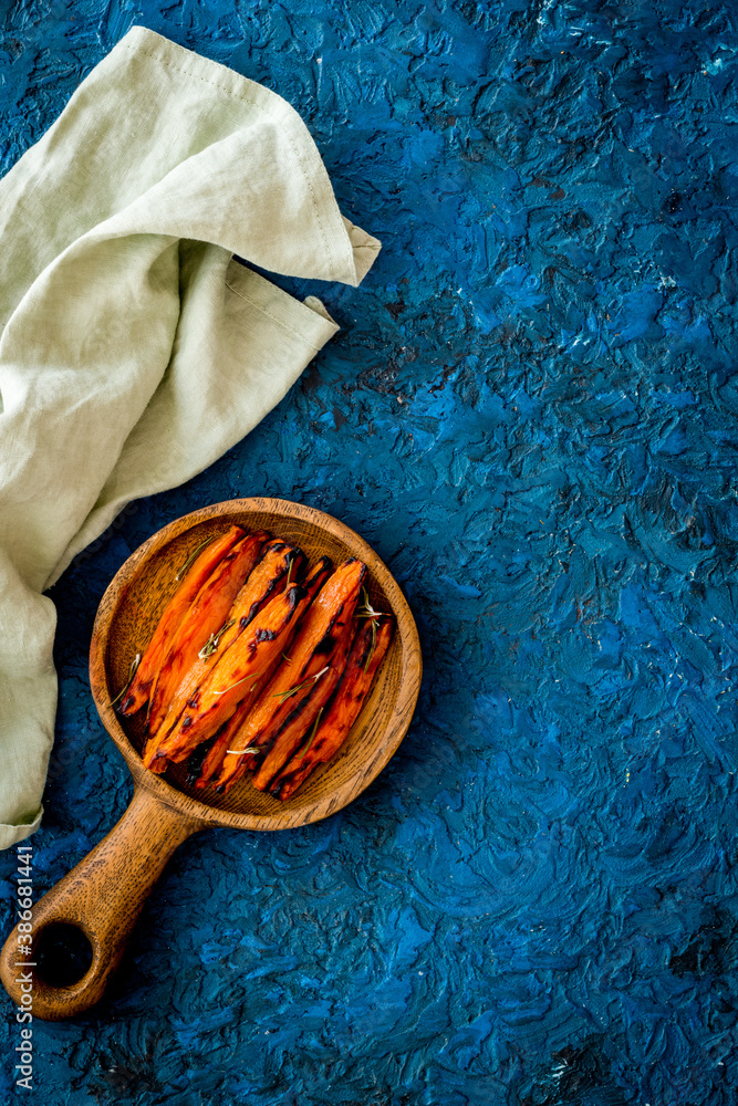 Sweet potato fries with spices on a wooden board, top view