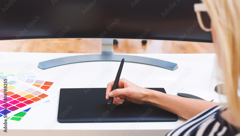 Graphic designer using her graphic tablet in an office