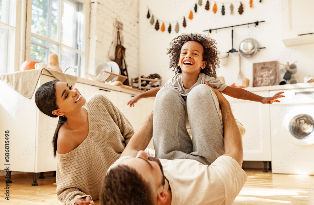 Happy multiracial family playing in kitchen.