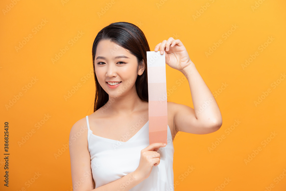 woman holding perfect skin choosing makeup foundation with skin tone palette.