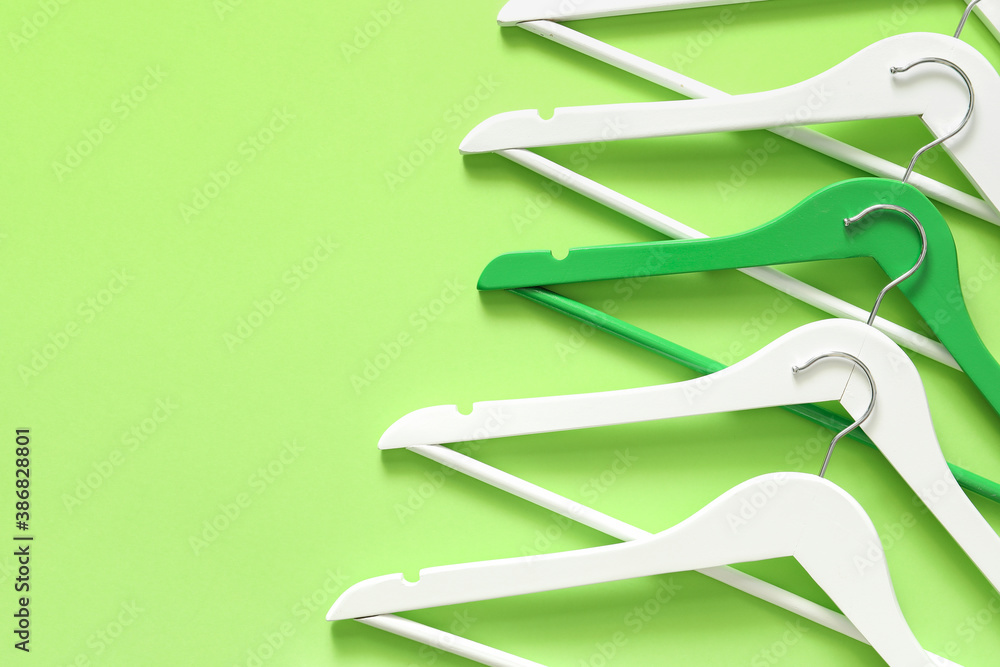 Clothes hangers on color background