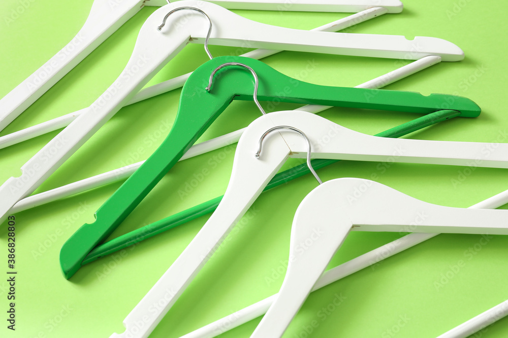 Clothes hangers on color background