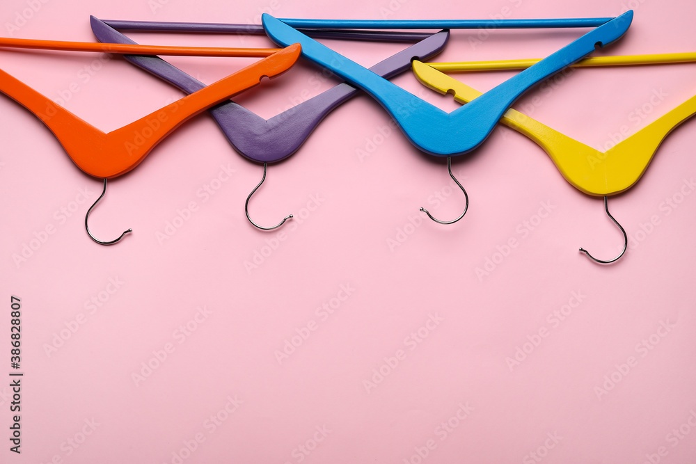 Clothes hangers on color background