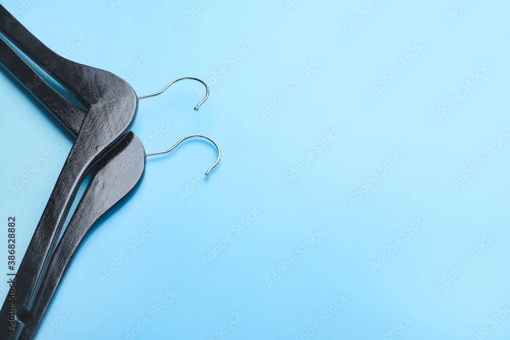 Clothes hangers on color background