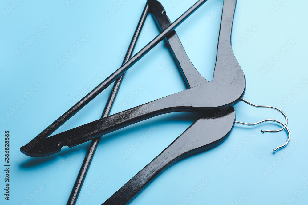 Clothes hangers on color background