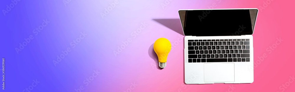 Laptop computer with a yellow light bulb from above