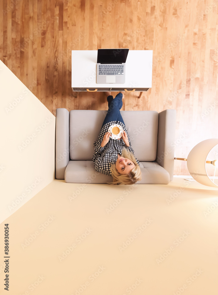 Young woman drinking a cup of coffee on a couch