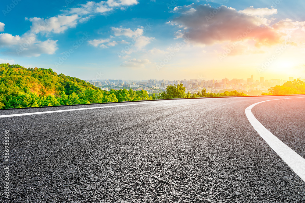 Asphalt road and city skyline with buildings in Hangzhou at sunrise.