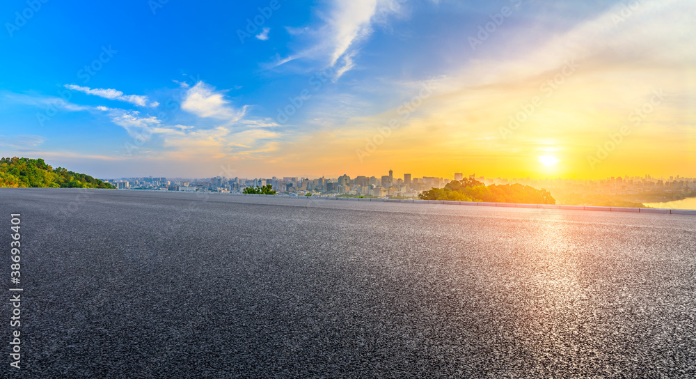 Asphalt road and city skyline with buildings in Hangzhou at sunrise.