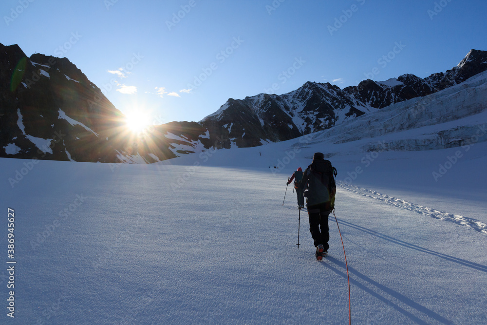 Rope team mountaineering with crampons on glacier Taschachferner towards Wildspitze and mountain sno