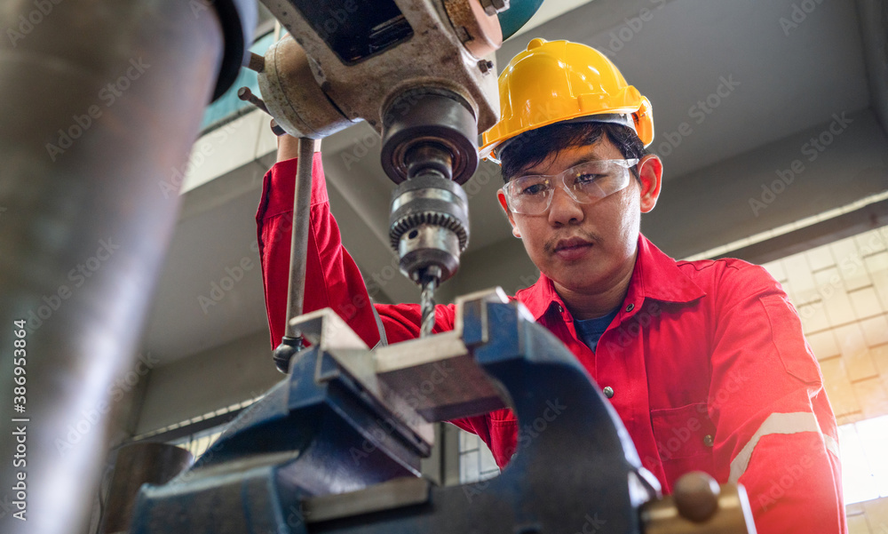 Asian man foreman working with drill press machinery with safety uniform concept smart manufacturing