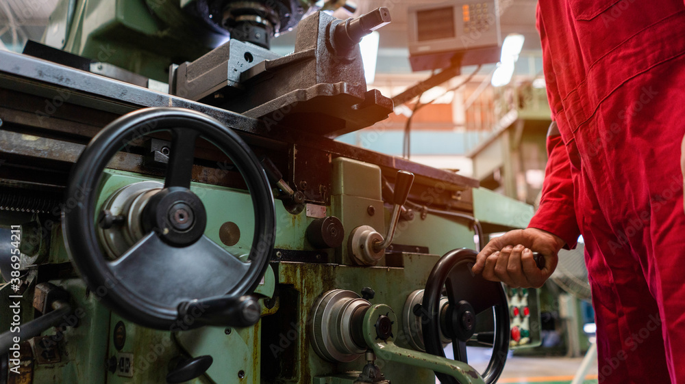 Asian man foreman working with NC Lathe machinery with safety uniform concept smart manufacturing in