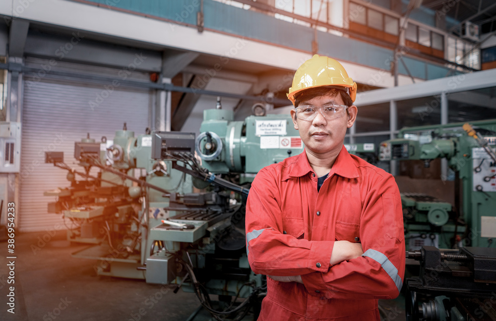 Asian man foreman working with NC Lathe machinery with safety uniform concept smart manufacturing in