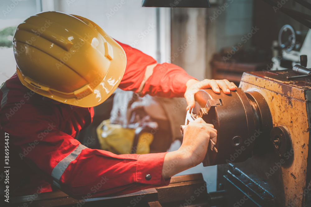 Asian man foreman working with NC Lathe machinery with safety uniform concept smart manufacturing in