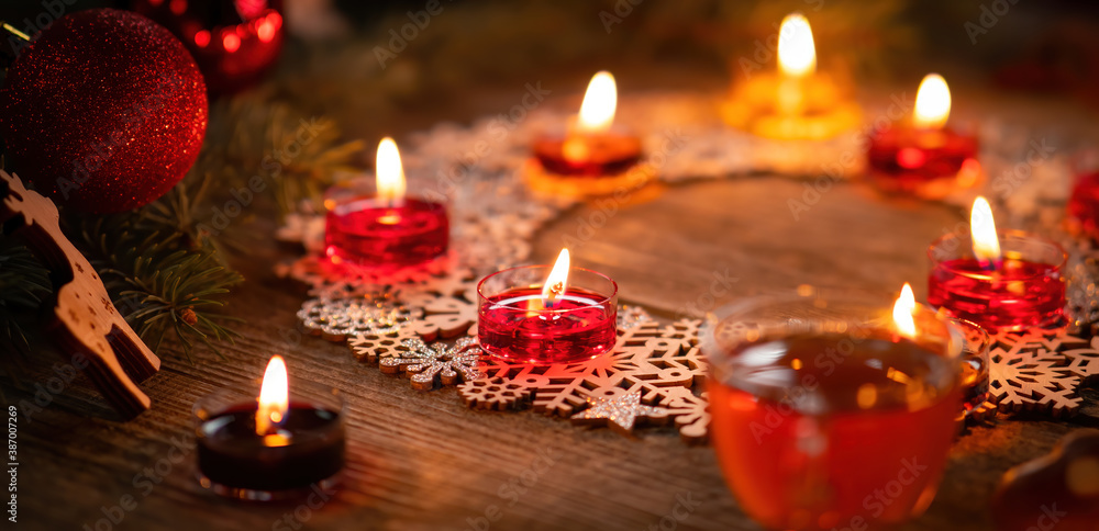 Winter ornamental decoration with burning candles on wooden rustic table. Mulled wine punch with gin