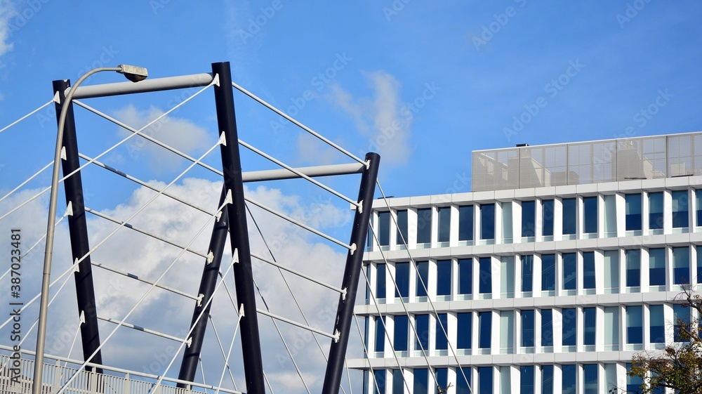 Blue curtain wall made of toned glass and steel constructions under blue sky. A fragment of a buildi