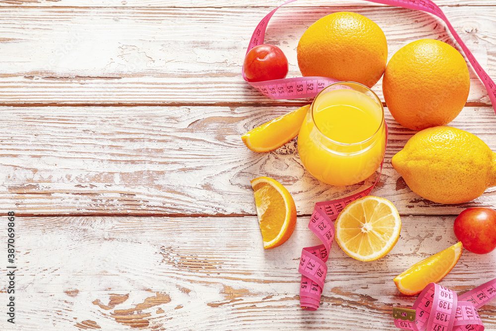 Fresh products and measuring tape on white wooden background. Diet concept