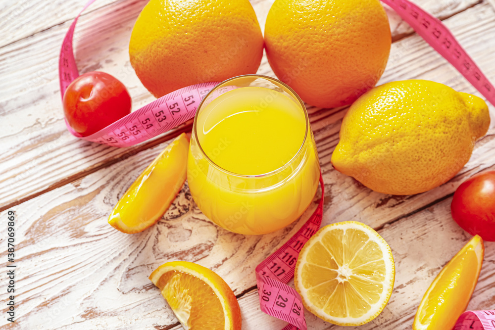 Fresh products and measuring tape on white wooden background. Diet concept