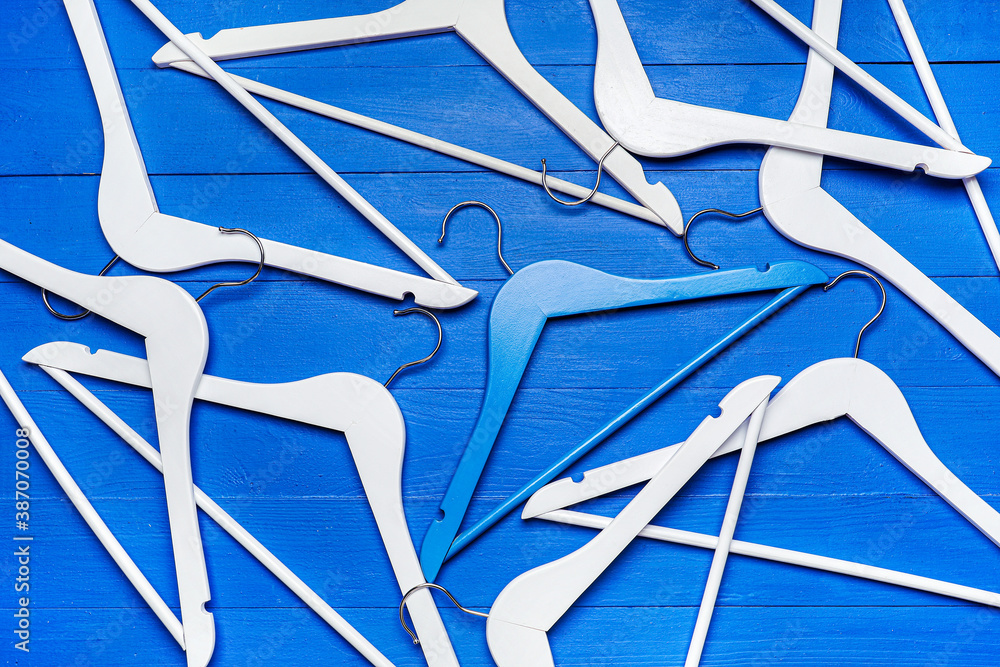 Clothes hangers on color background