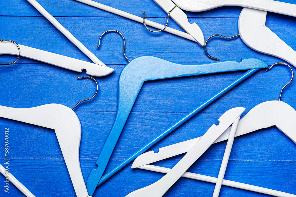 Clothes hangers on color background