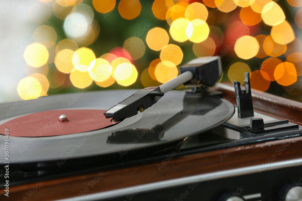 Record player against blurred Christmas lights, closeup