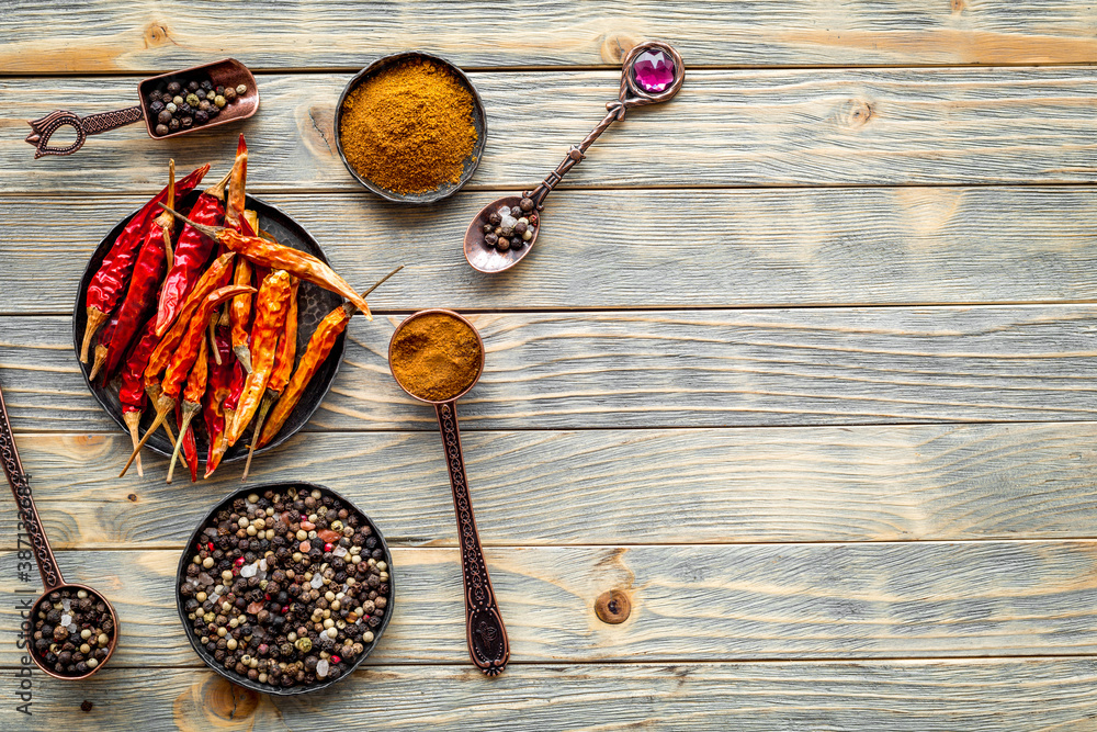 Cooking utensils and hot spices in metal bowls and spoons. Top view