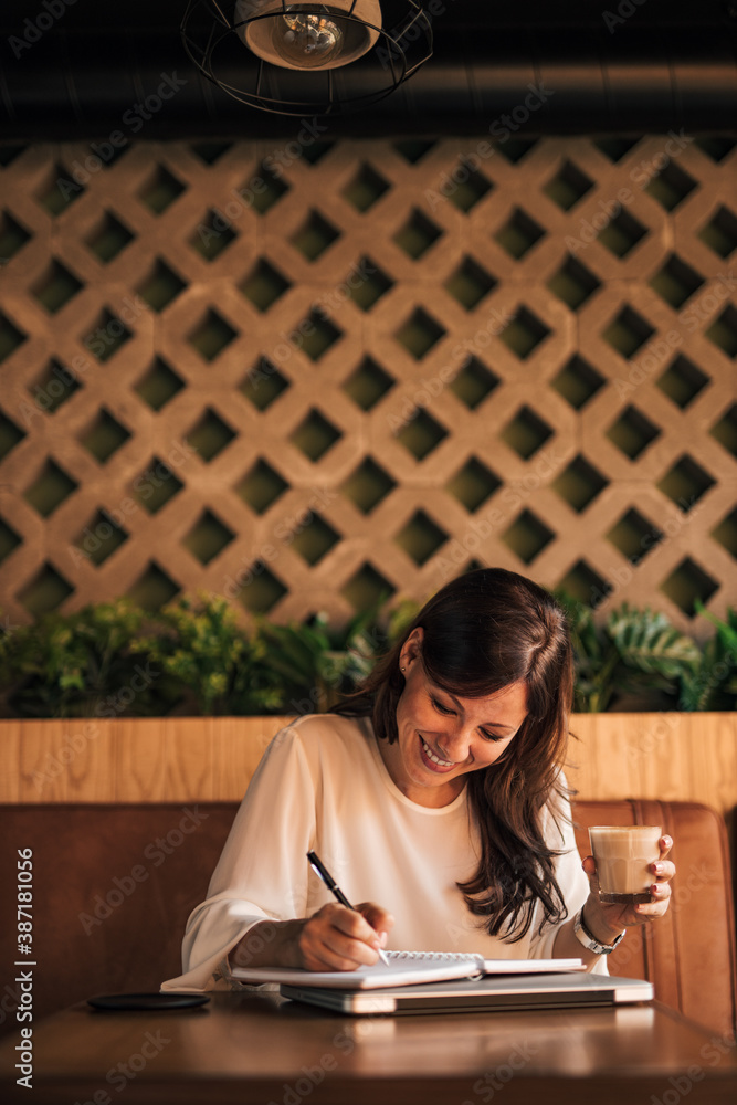 Brunette woman with coffee in her hands.