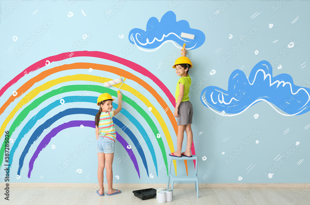 Children painting colorful rainbow and clouds on wall