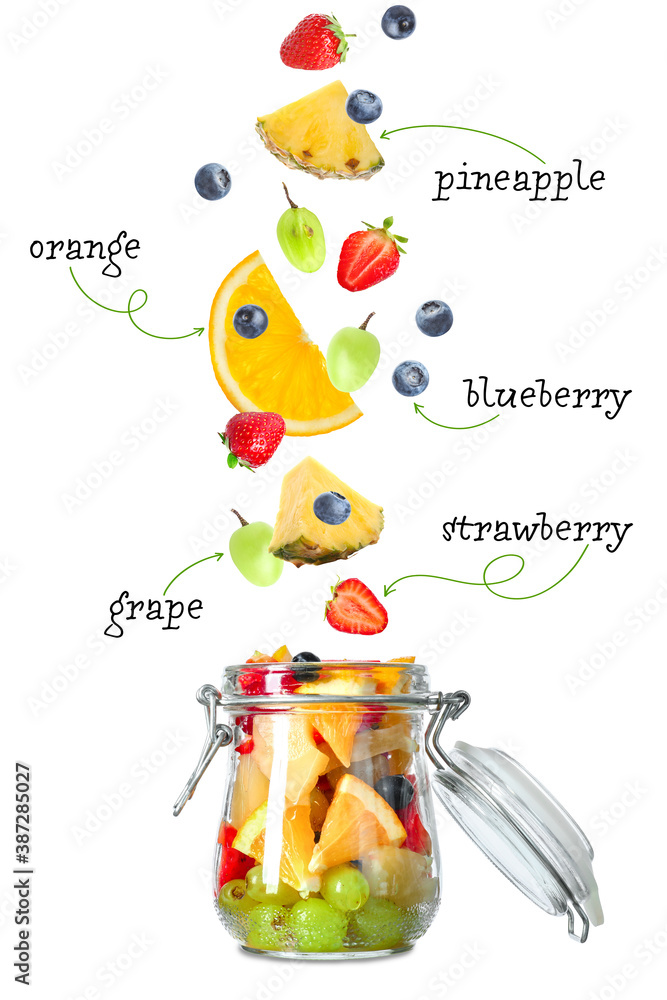 Jar with tasty fruit salad and flying ingredients on white background