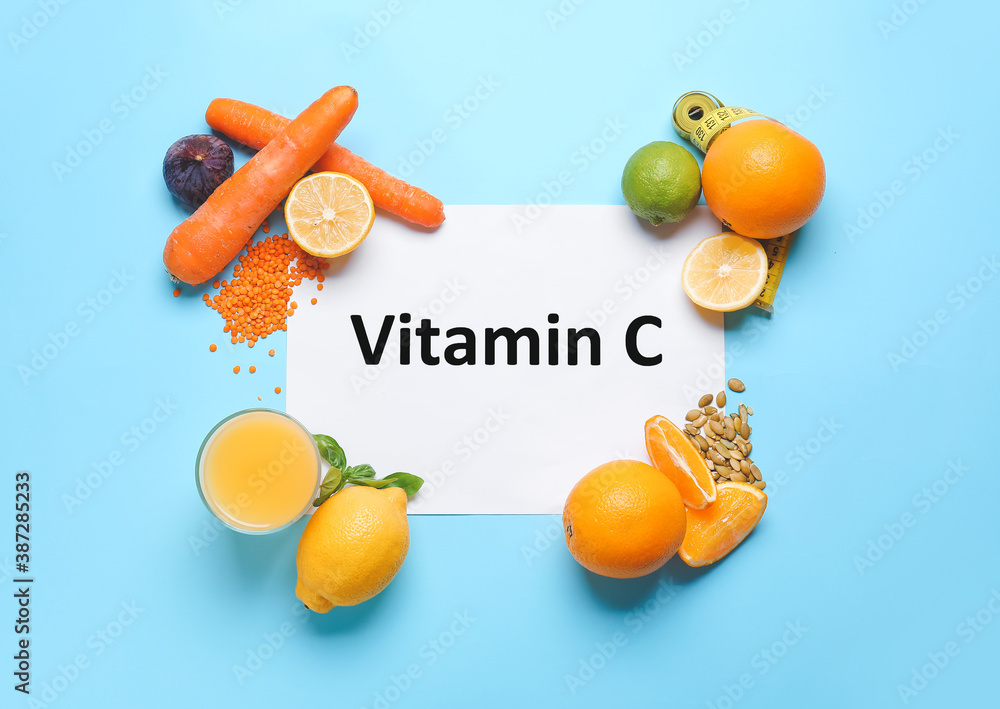 Paper sheet with text VITAMIN C and fresh products on color background