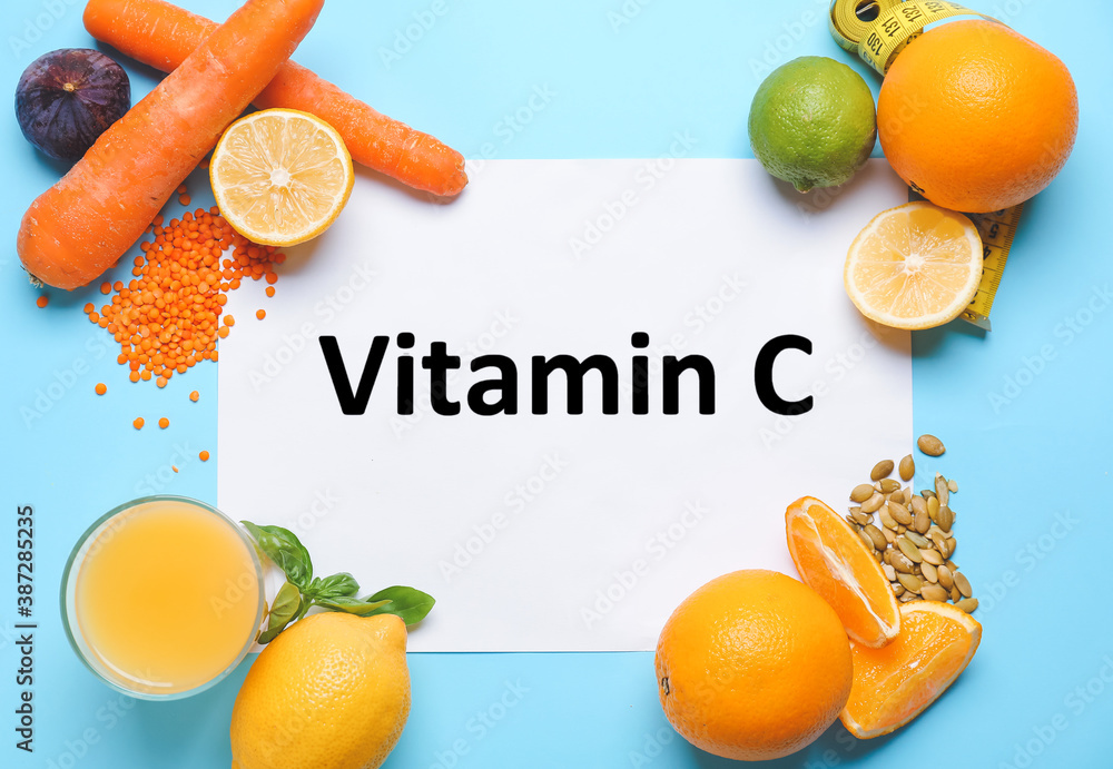 Paper sheet with text VITAMIN C and fresh products on color background