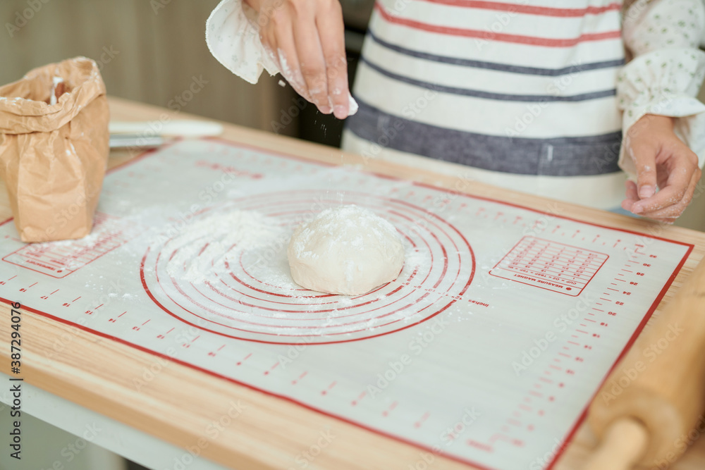 Hands knead the dough, flour, rolling pin, on the table