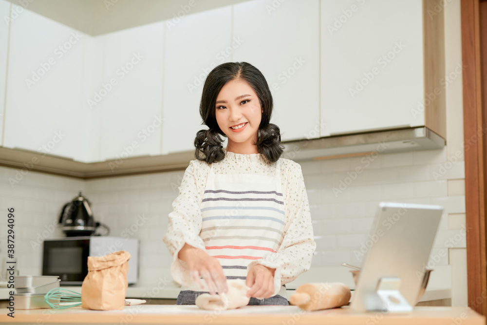 Positive female working with dough and smiling