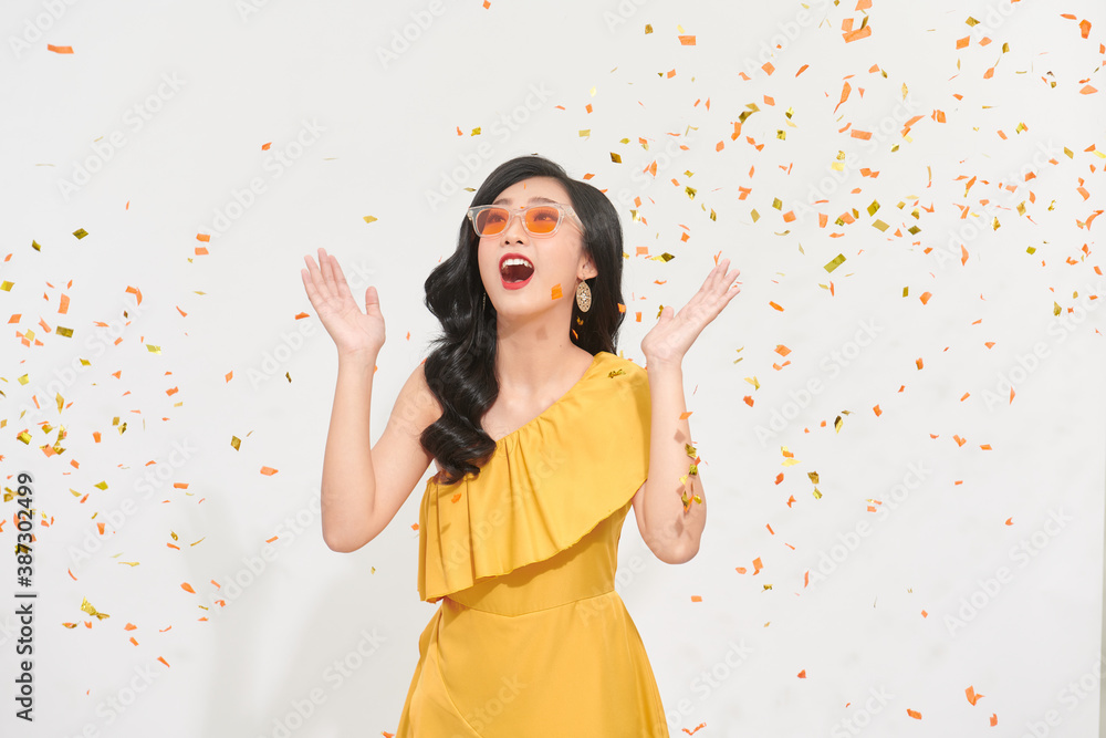 Image of happy young woman posing isolated over white background wall over confetti.