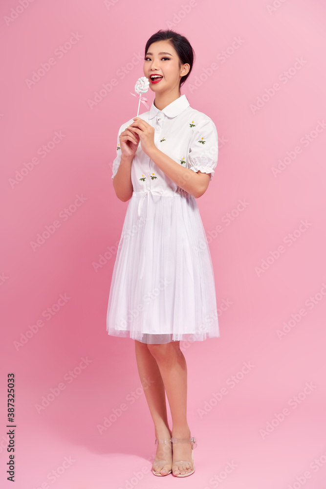 Young pretty woman with candies on colorful background