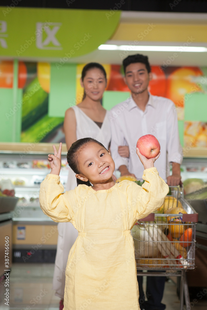 A happy family of three in the supermarket shopping