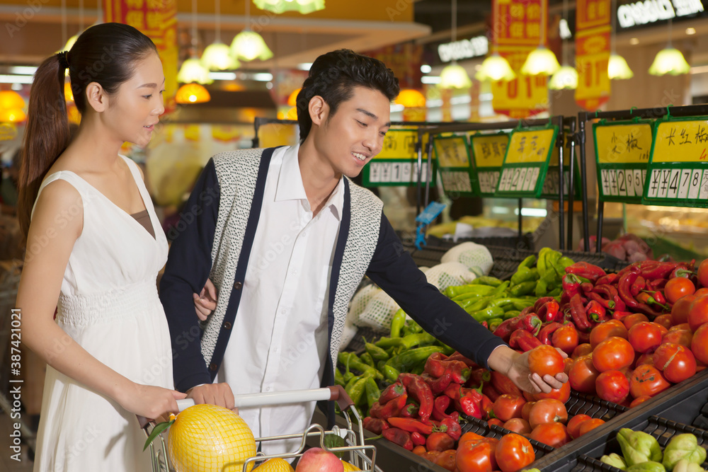 A young couple in the supermarket shopping