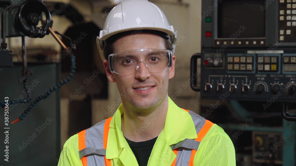 Young factory worker or engineer close up portrait in factory . Industry and engineering concept .