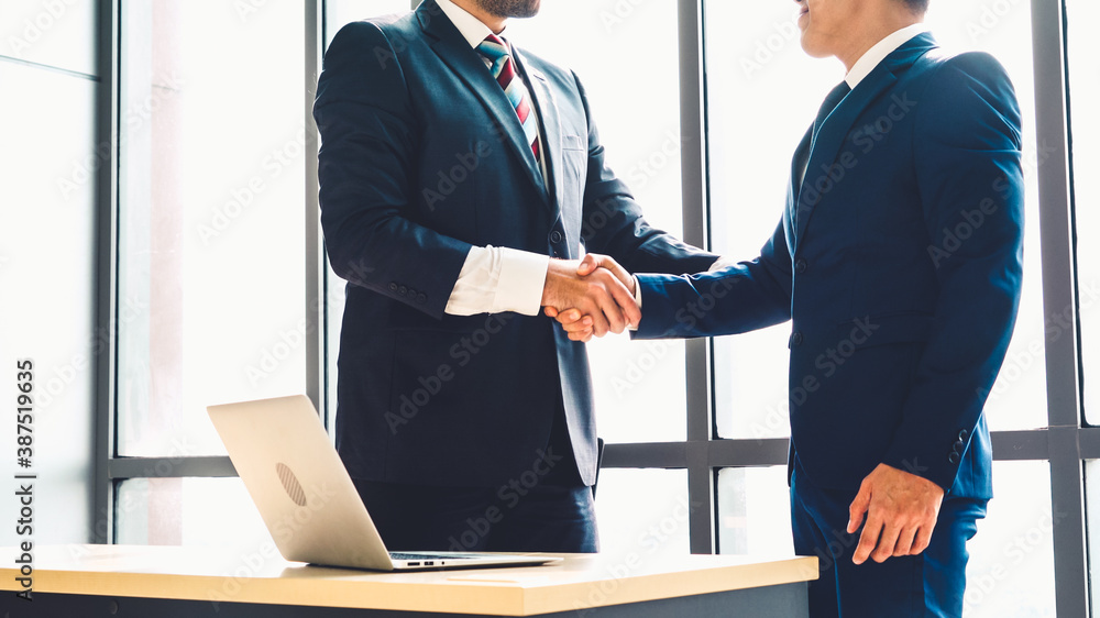 Business people handshake in corporate office showing professional agreement on a financial deal con