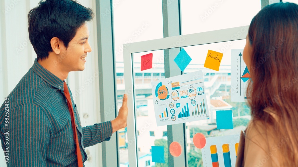 Business people work on project planning board in office and having conversation with coworker frien