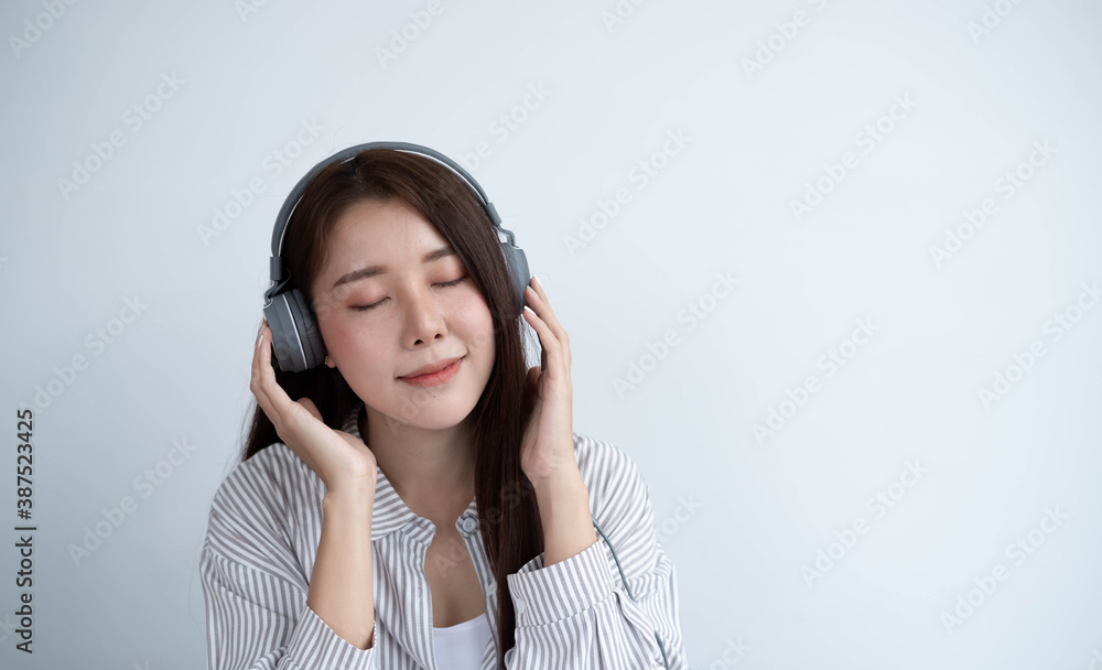 Beautiful and lovely Asian women wear headphones to listen to the music they like, their faces are v