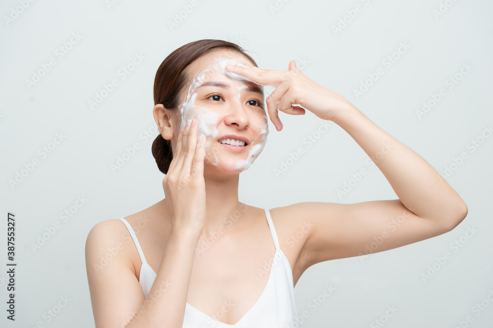 Face skin care. Woman applying facial cleanser on face closeup. Girl using cleansing cosmetic produc