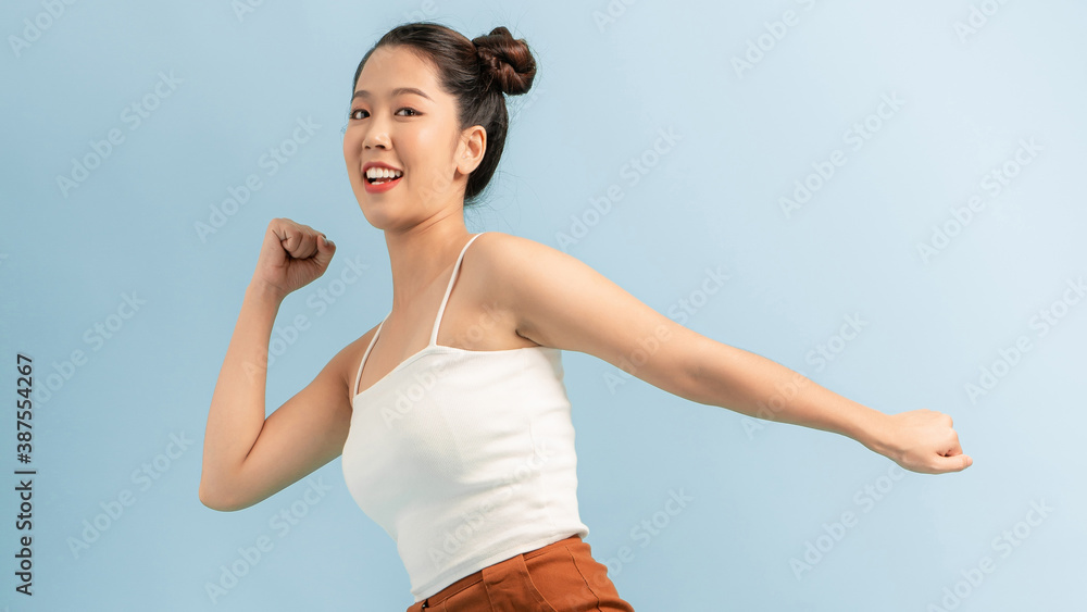 happy young excited shocked woman posing isolated over blue wall background looking aside.